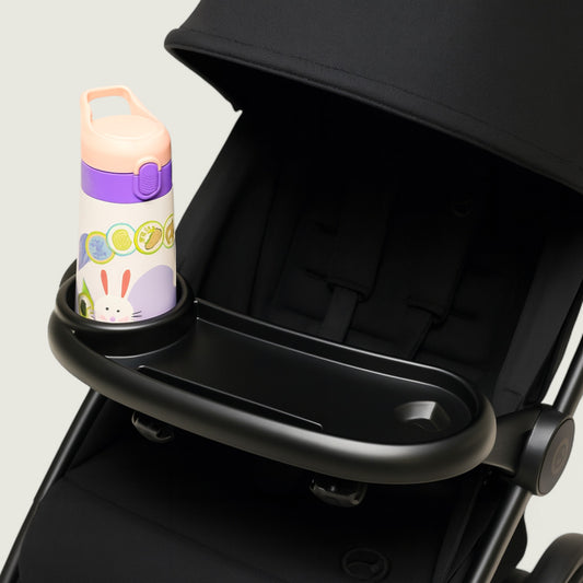 Black stroller with a cup holder containing a colorful water bottle on a light gray background