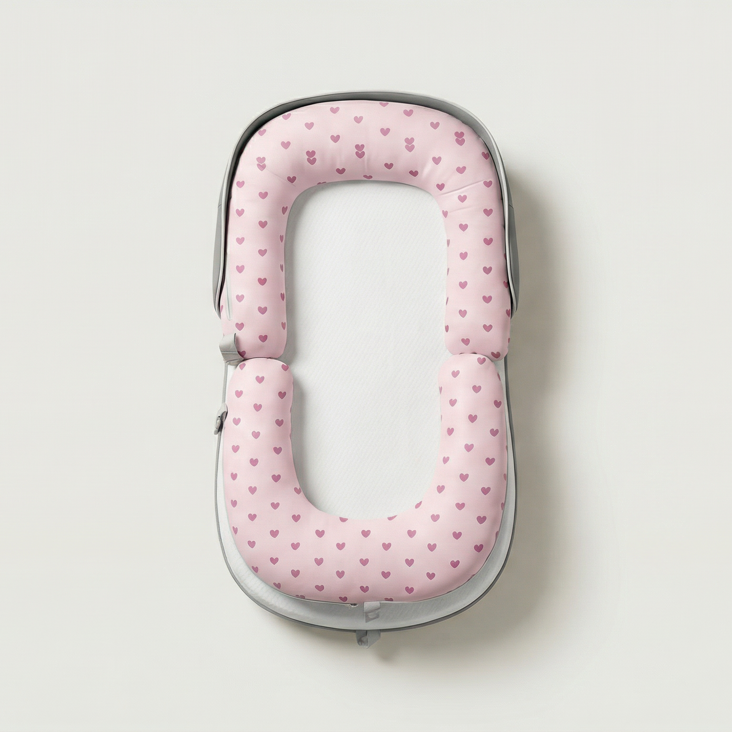 Pink polka dot travel pillow on a light gray background