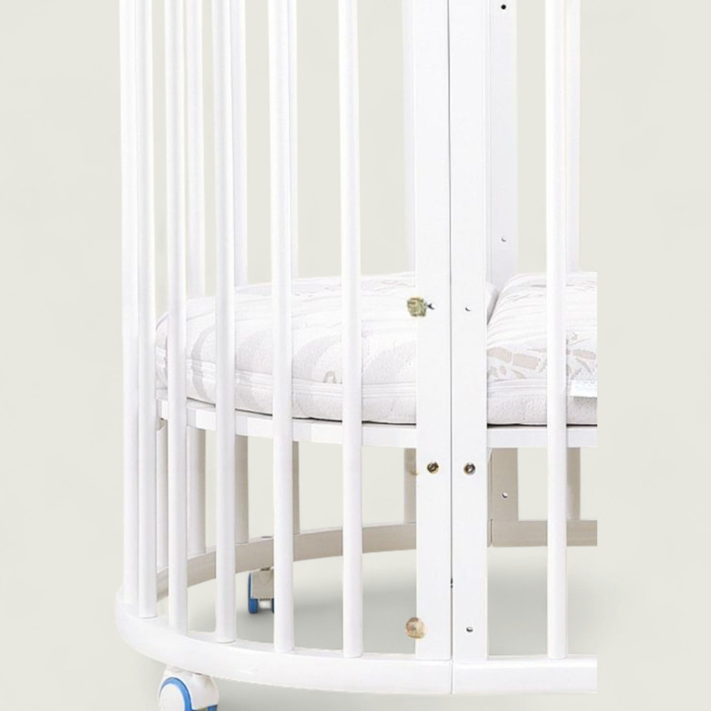 White crib with a white mattress in a minimalistic room.