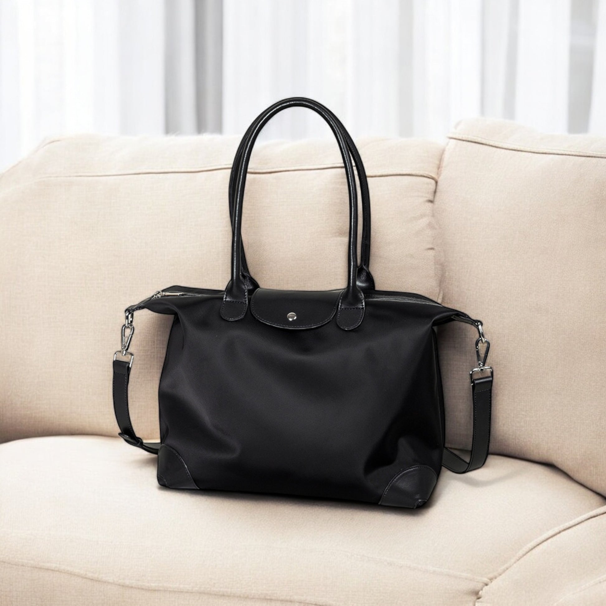 Black handbag on a beige sofa with a neutral background