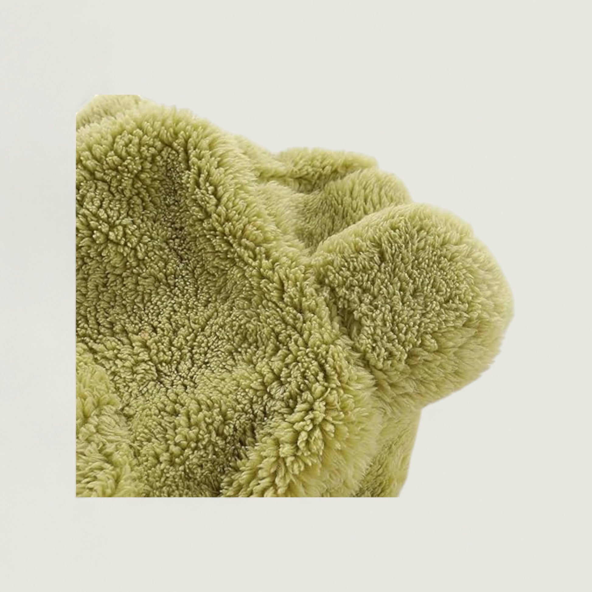 Green textured blanket on a light beige background
