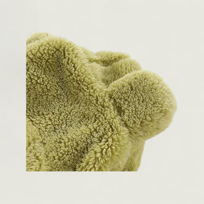 Green textured blanket on a light beige background
