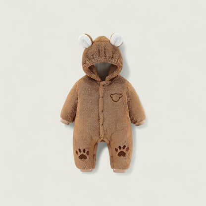 Brown baby onesie with bear ears and paw prints on a beige background
