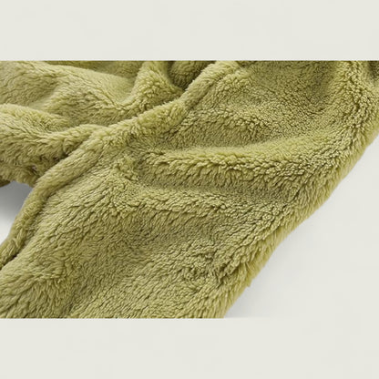 Close-up of a green textured blanket on a light gray background