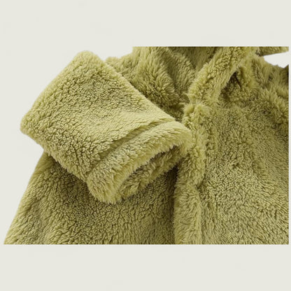 Folded green towel on a light beige background