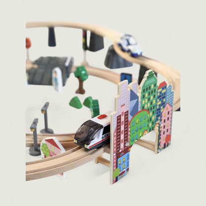 Wooden toy train set with tracks and colorful buildings on a light gray background