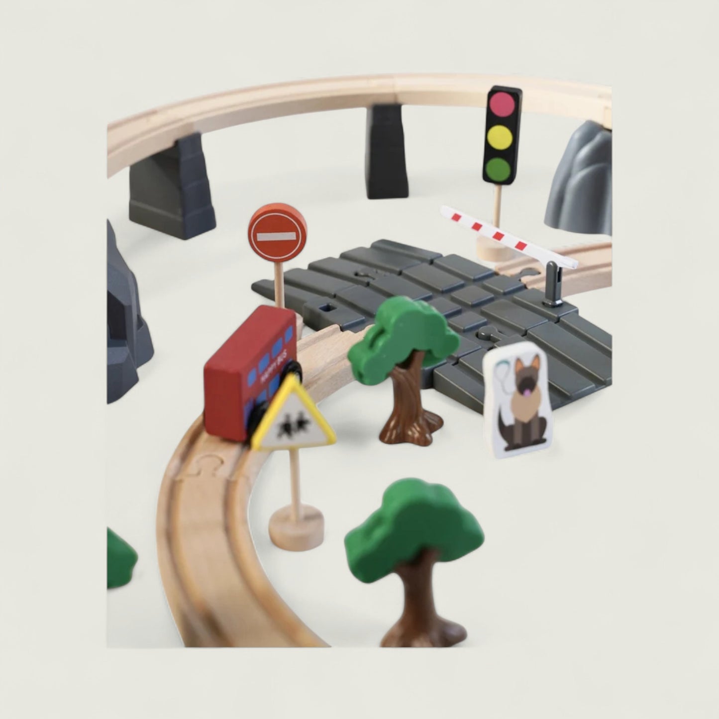 Toy train set with tracks, traffic lights, and trees on a light gray background