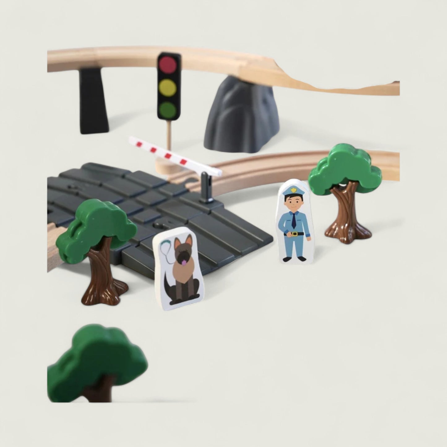 Toy setup with traffic light, crossing gate, trees, and figures on a plain background