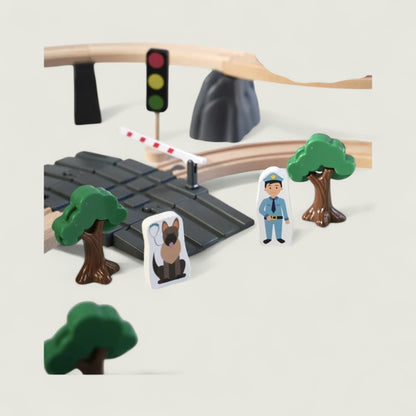 Toy setup with traffic light, crossing gate, trees, and figures on a plain background