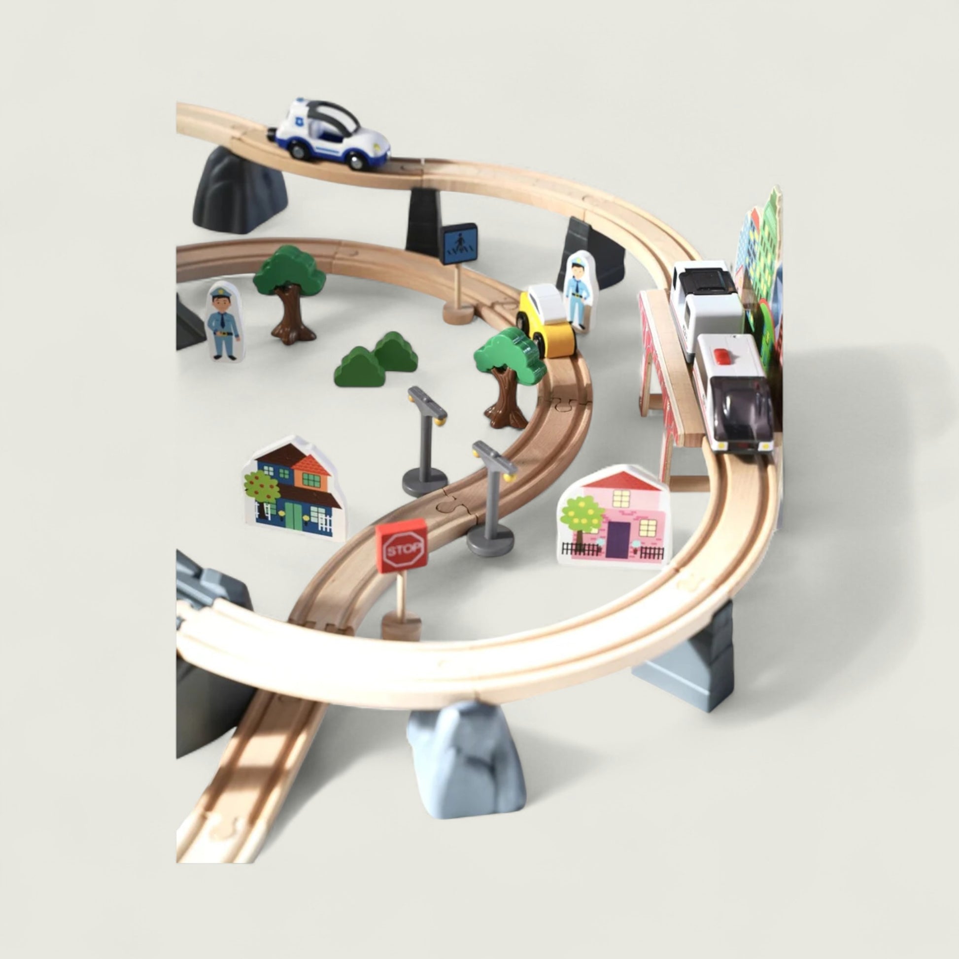 Toy train set with tracks, cars, and small buildings on a light gray background