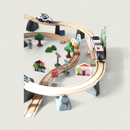 Toy train set with tracks, cars, and small buildings on a light gray background