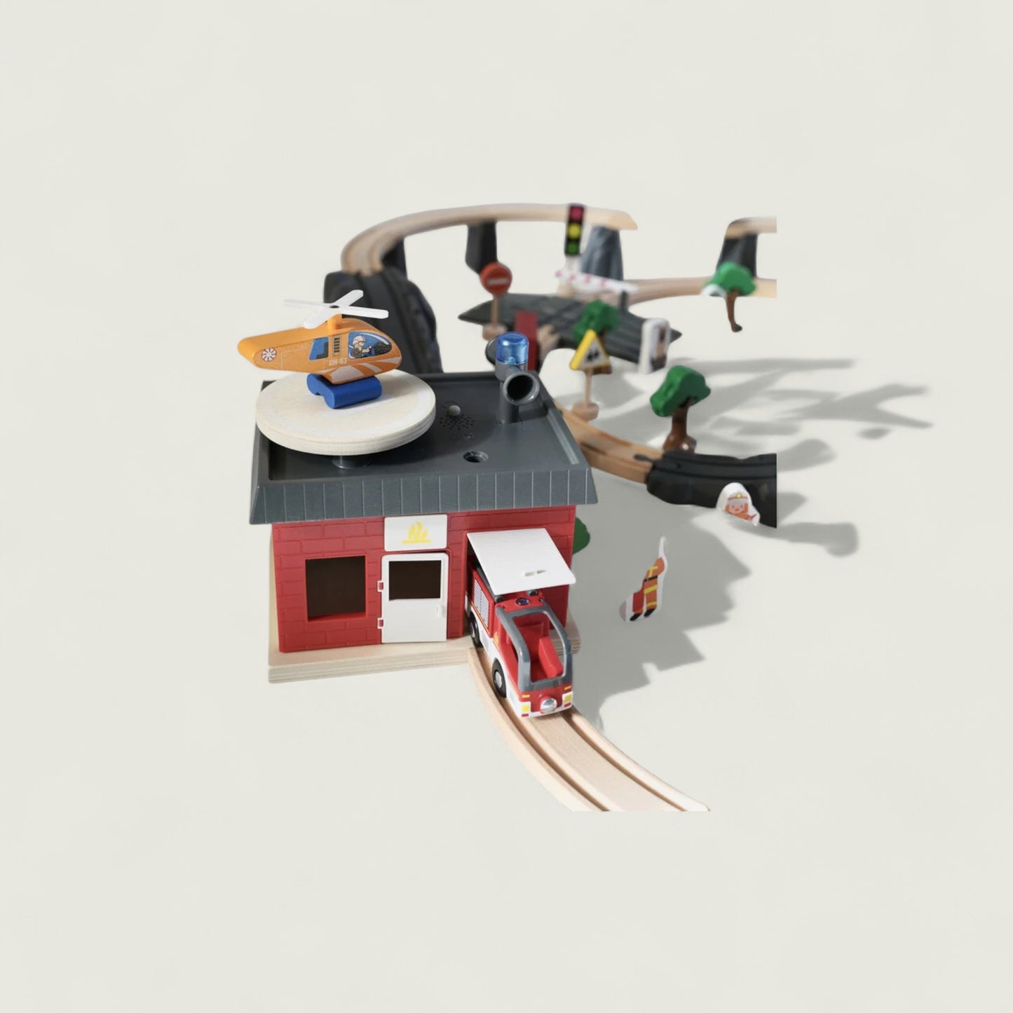 Toy set with a red building, train, and various figures on a light gray background