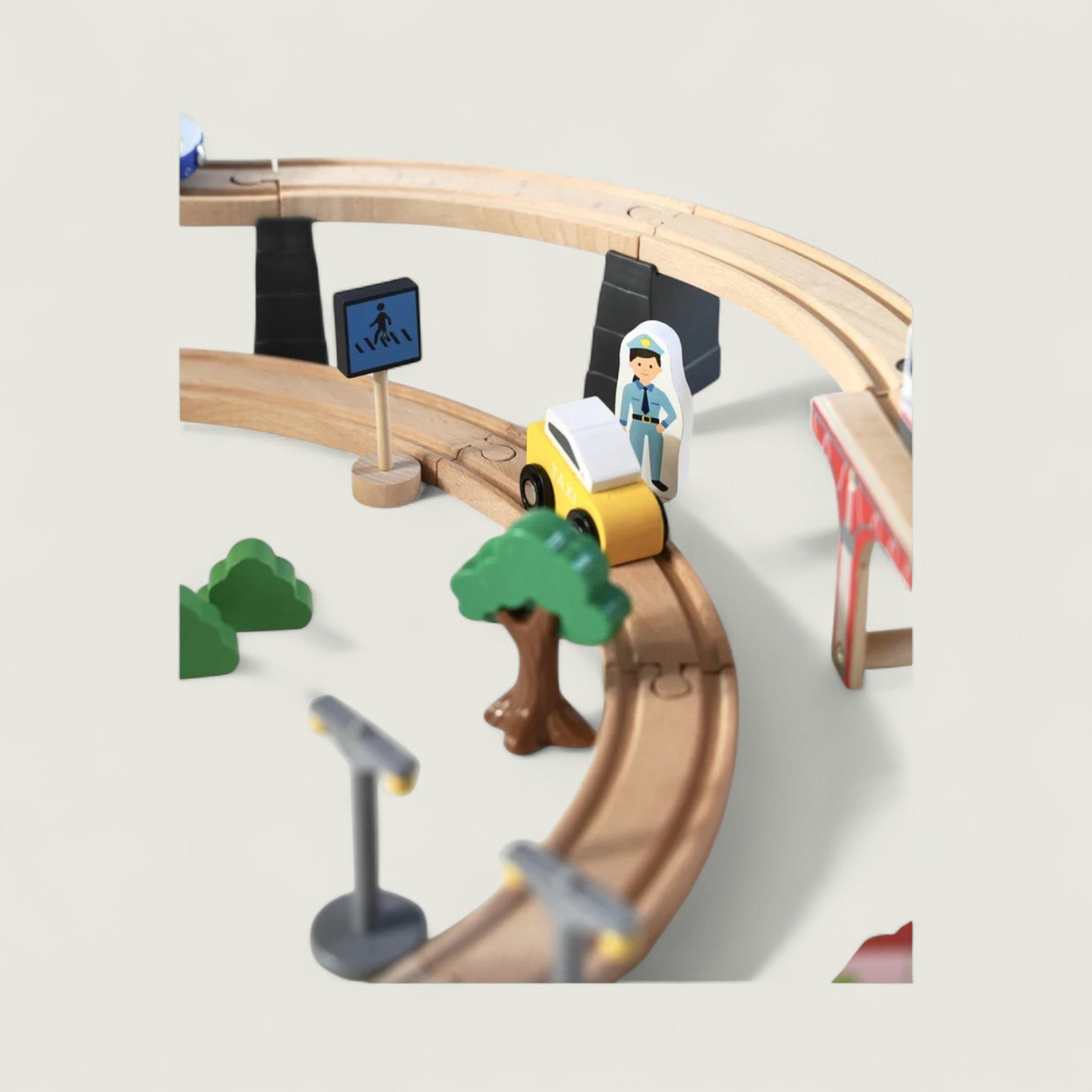 Toy train set with tracks, cars, and traffic lights on a light gray background