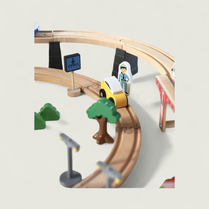 Toy train set with tracks, cars, and traffic lights on a light gray background