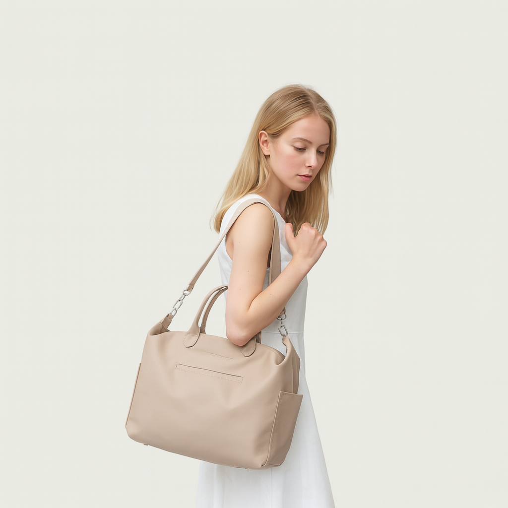 Woman holding a beige handbag against a plain background