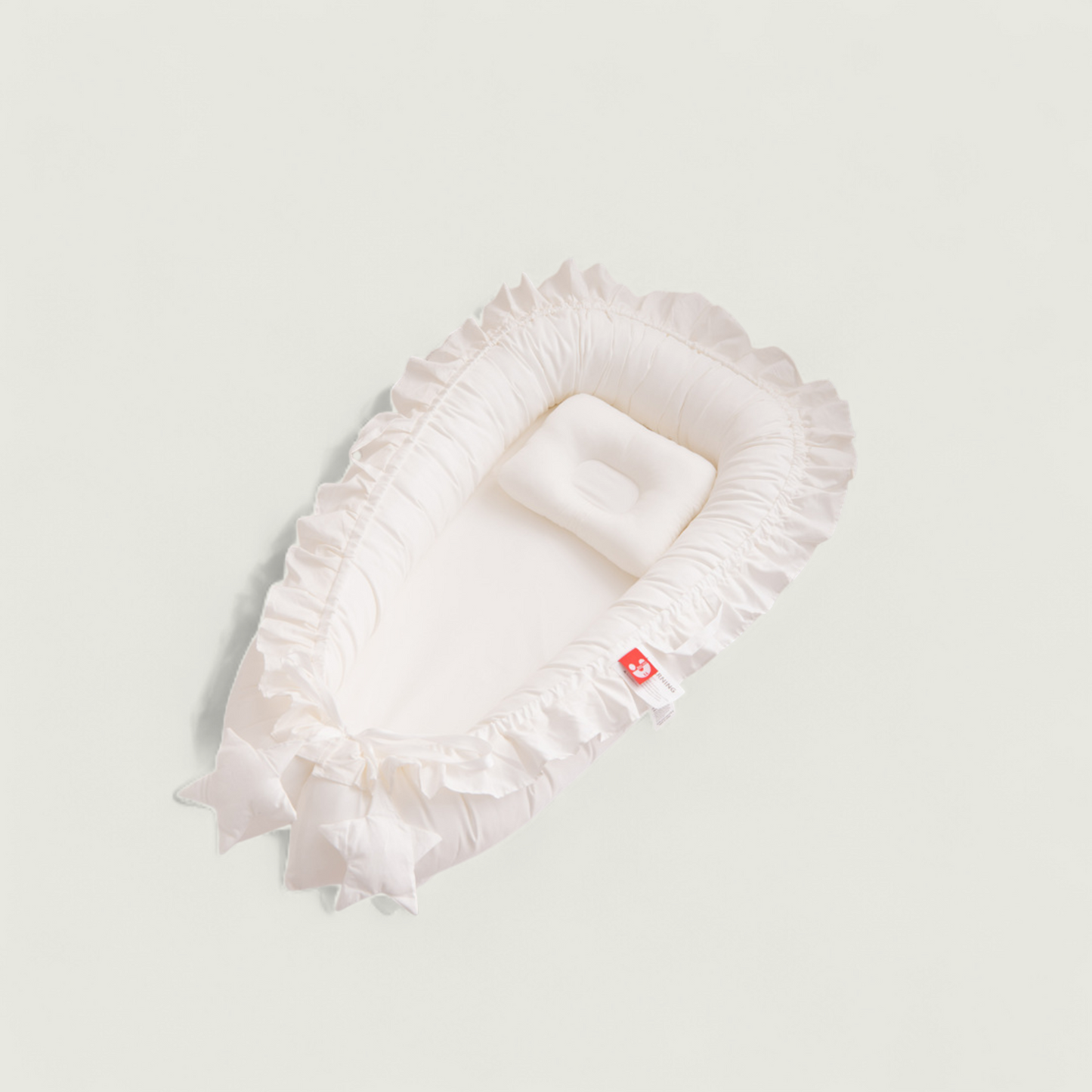 White ruffled headband with a small red tag on a light gray background