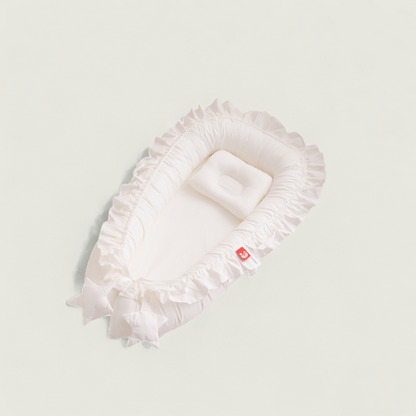 White ruffled headband with a small red tag on a light gray background