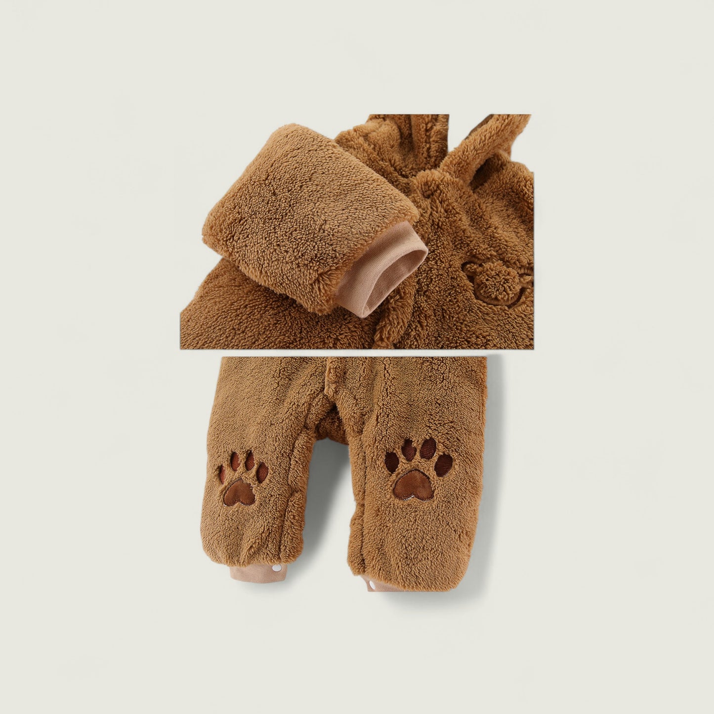 Brown teddy bear-themed baby outfit with a hood and paw prints on a light gray background