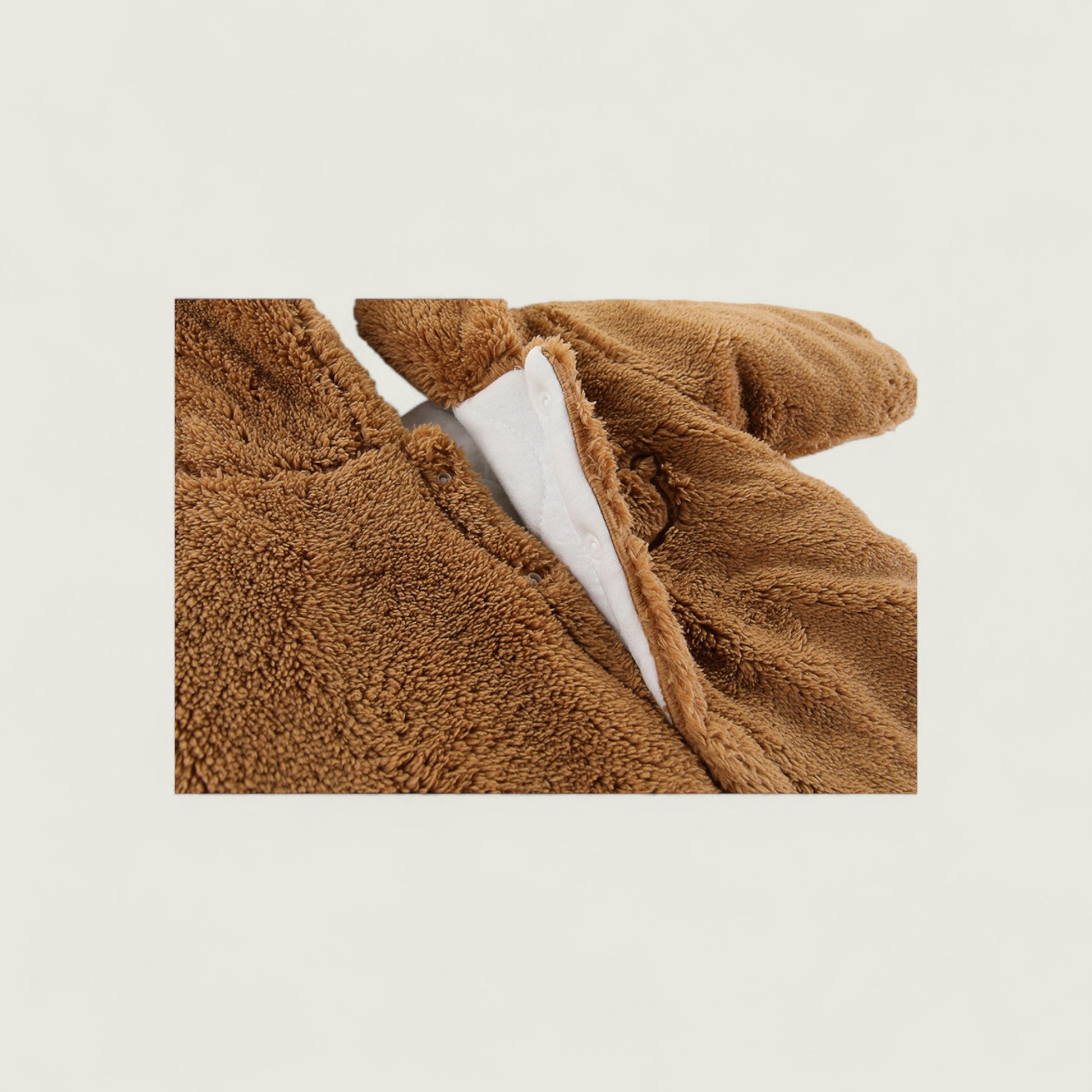 Brown plush blanket with white lining on a beige background