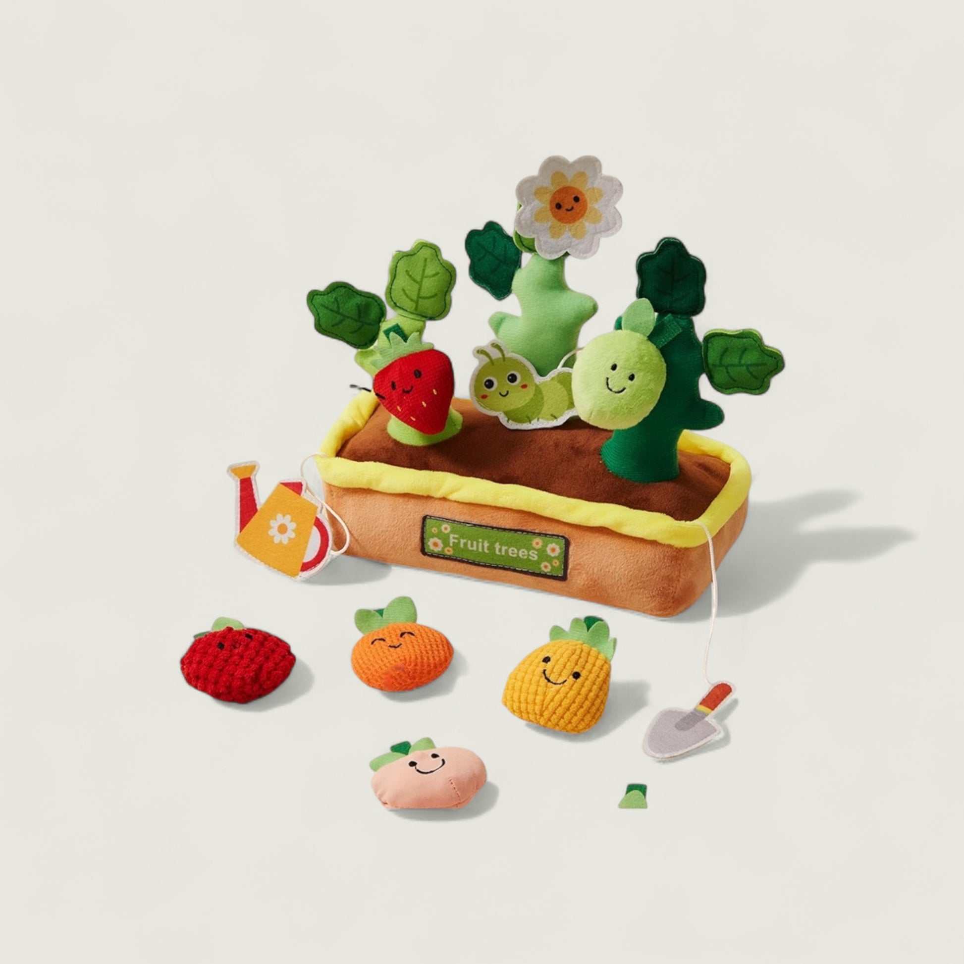 Toy fruit and vegetable set with a planting box on a light beige background