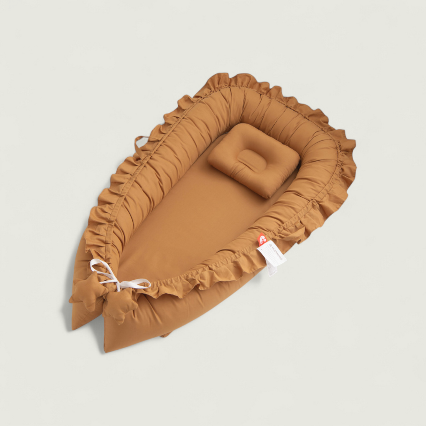 Brown baby crib with ruffled edges on a beige background