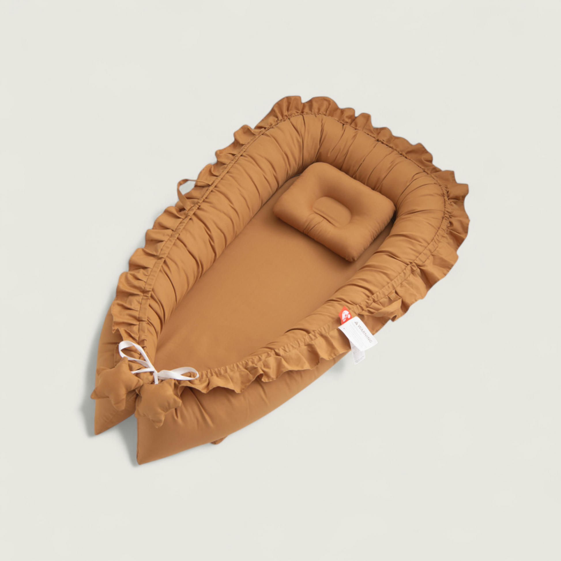 Brown baby crib with ruffled edges on a beige background