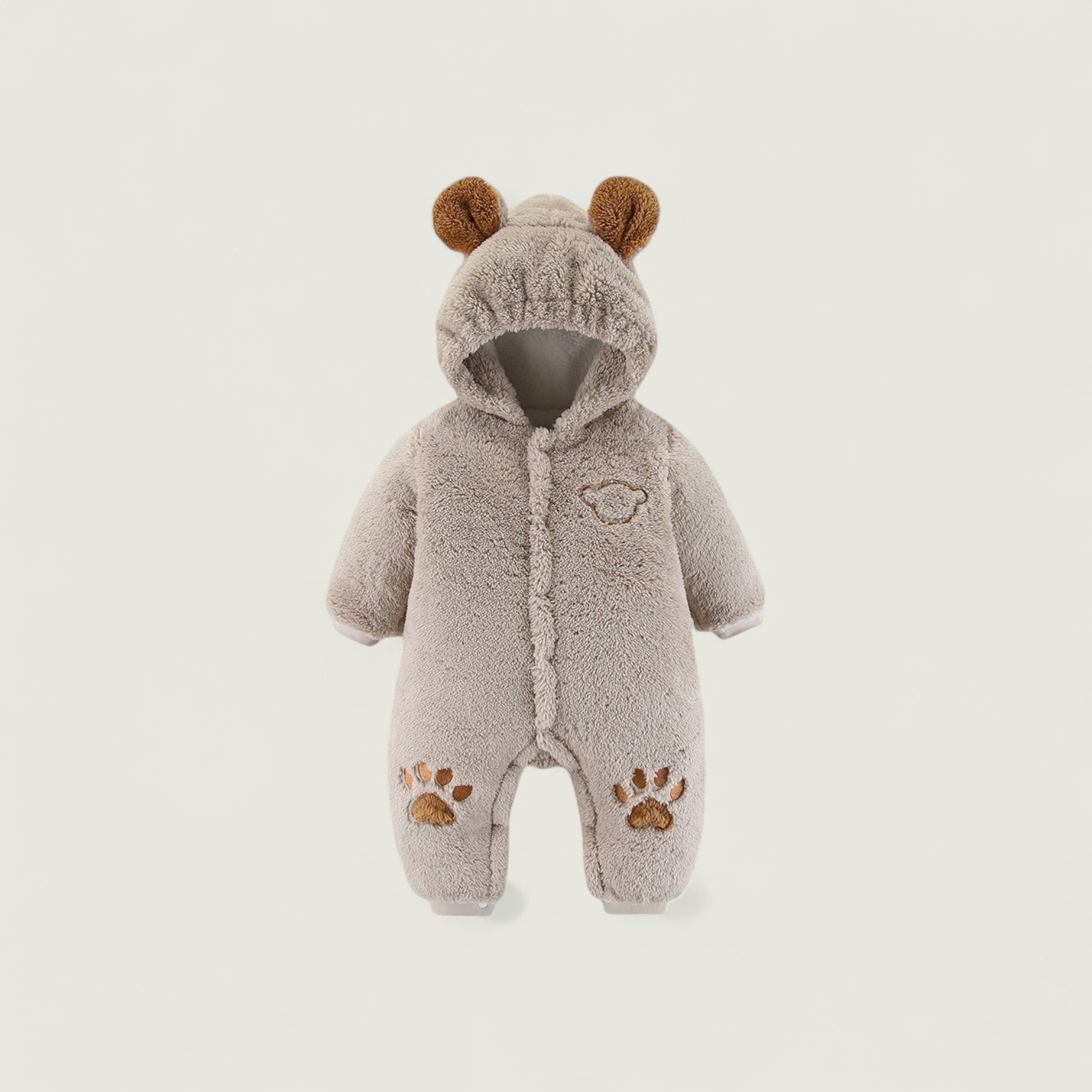 Children's gray onesie with bear ears and paw prints on a light gray background