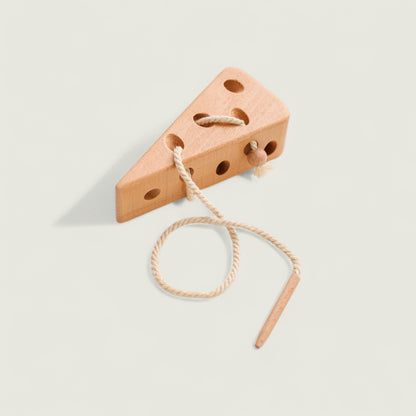Wooden wedge-shaped toy with a string on a light gray background