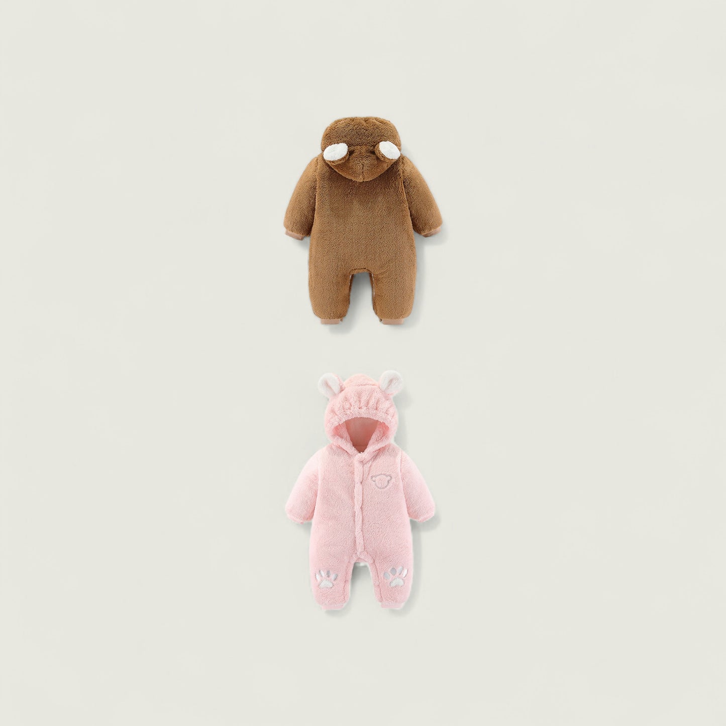 Brown and pink baby onesies on a light beige background