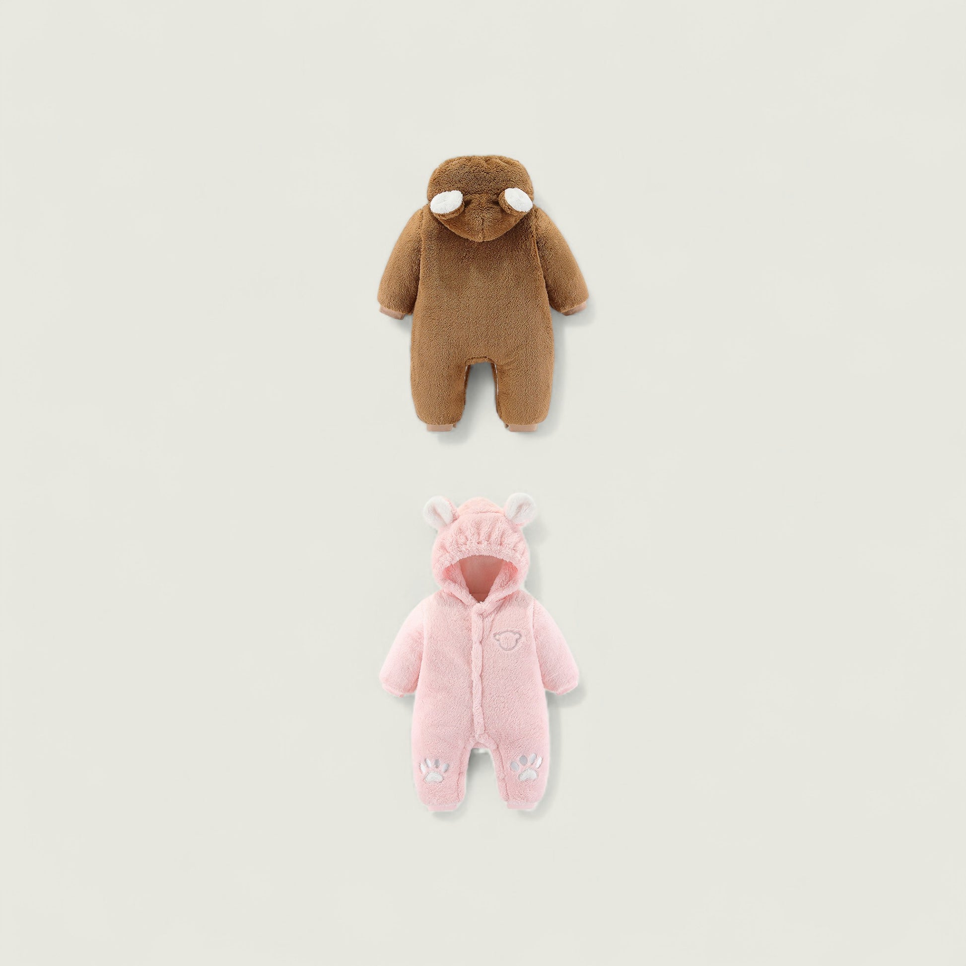 Brown and pink baby onesies on a light beige background