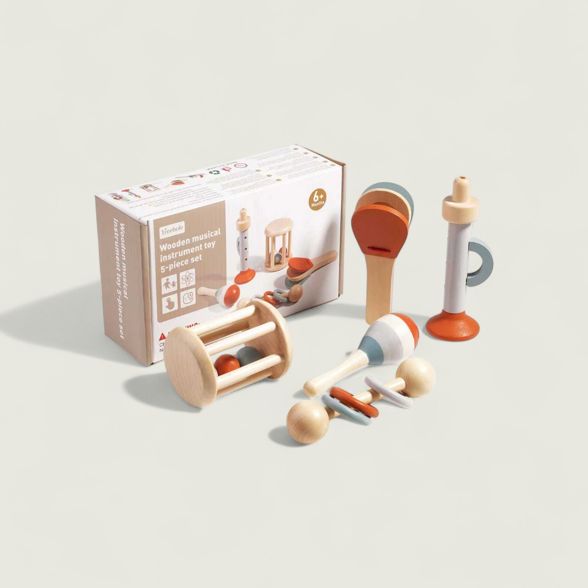Set of wooden baby toys with packaging on a light background