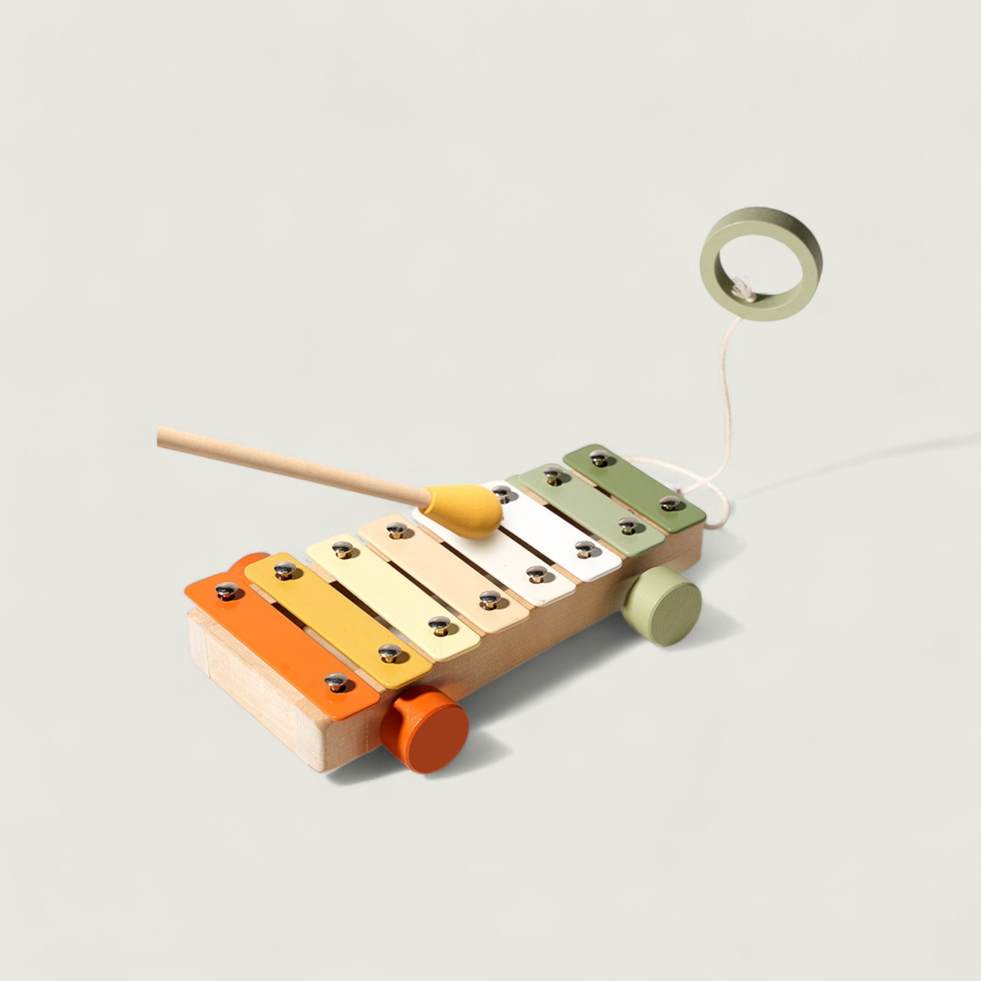Colorful wooden xylophone toy with a stick on a light gray background