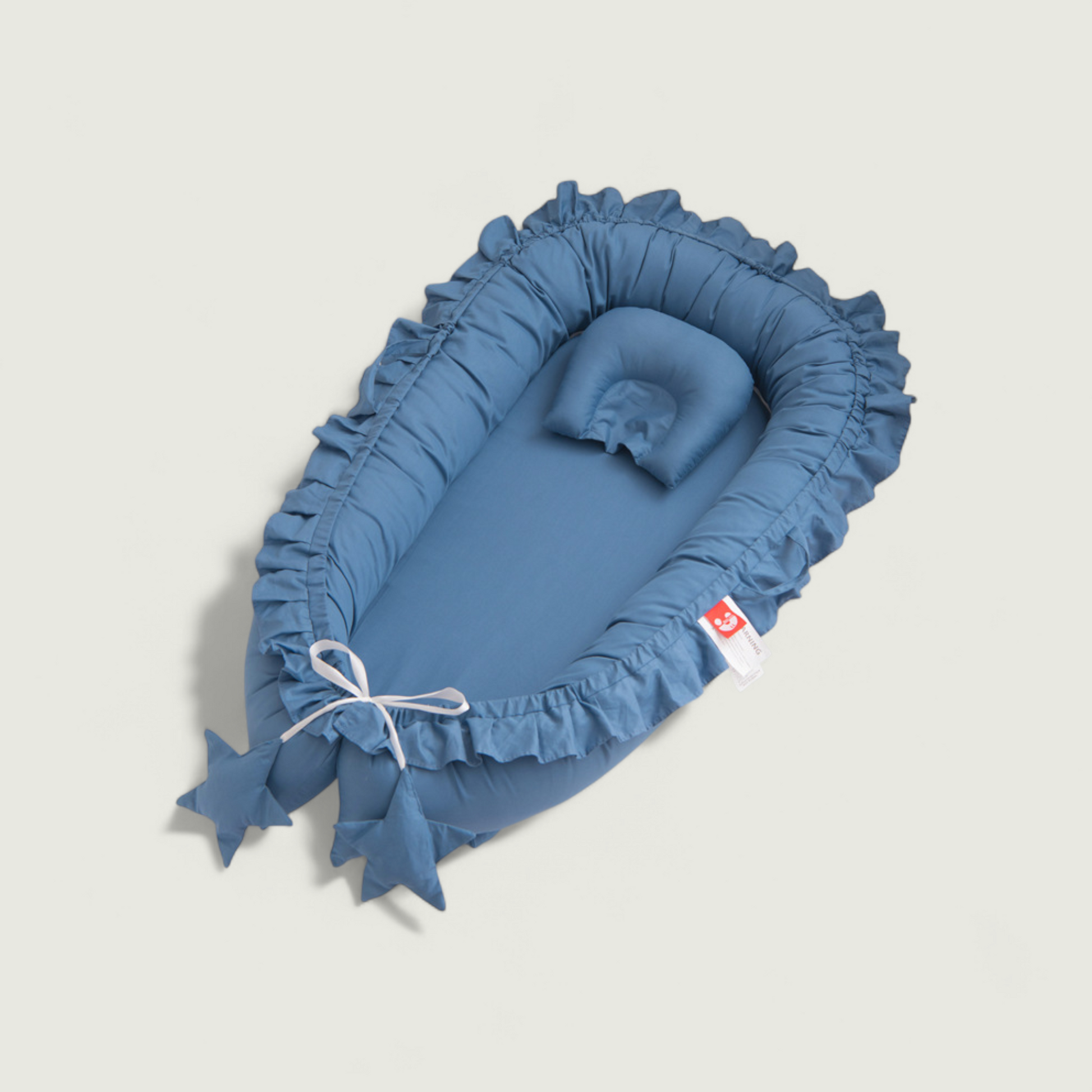 Blue baby crib with ruffled edges on a light gray background