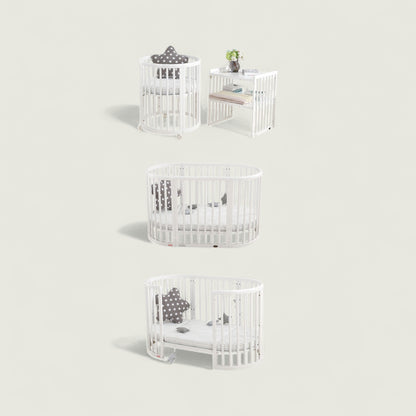 White crib with baby accessories on a light gray background