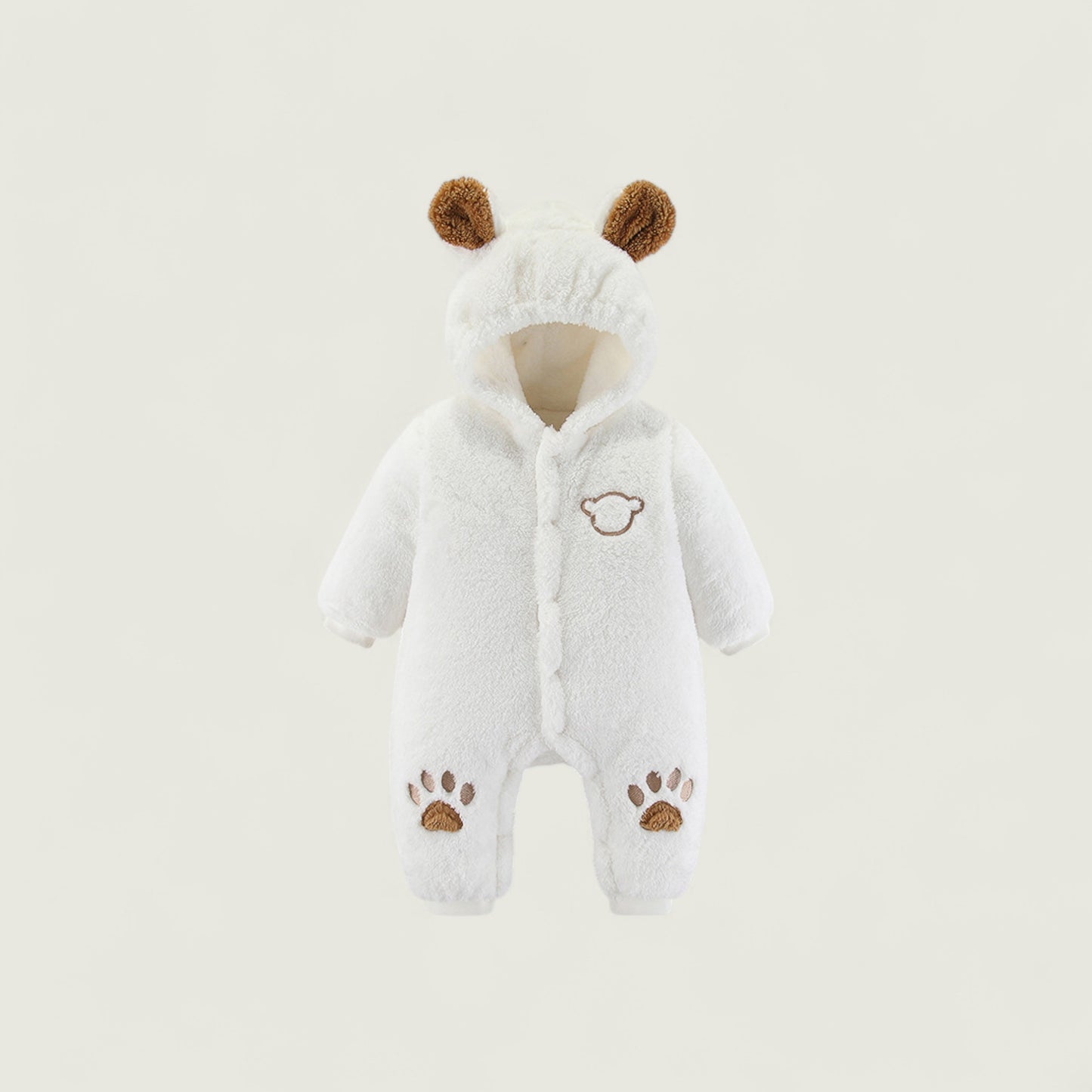 White baby snowsuit with brown accents on a light beige background