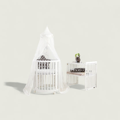 White crib with canopy and matching changing table against a light gray background