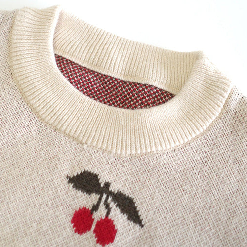 Beige sweater with cherry design on a white background