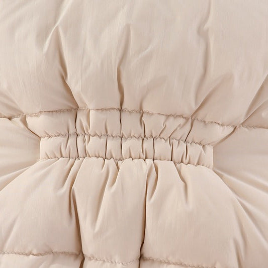 Close-up of beige quilted jacket with a focus on the waistband and stitching.