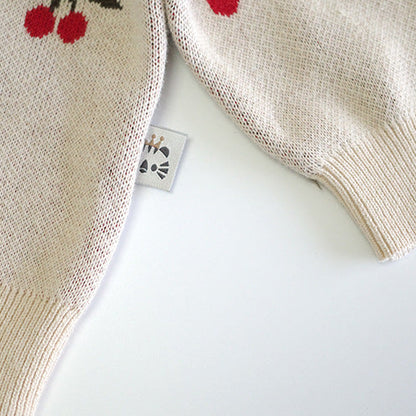Beige knitted sweater with cherry design on a white background