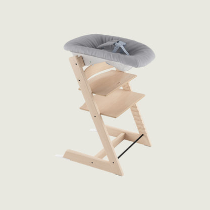 Wooden high chair with a gray cushion on a white background