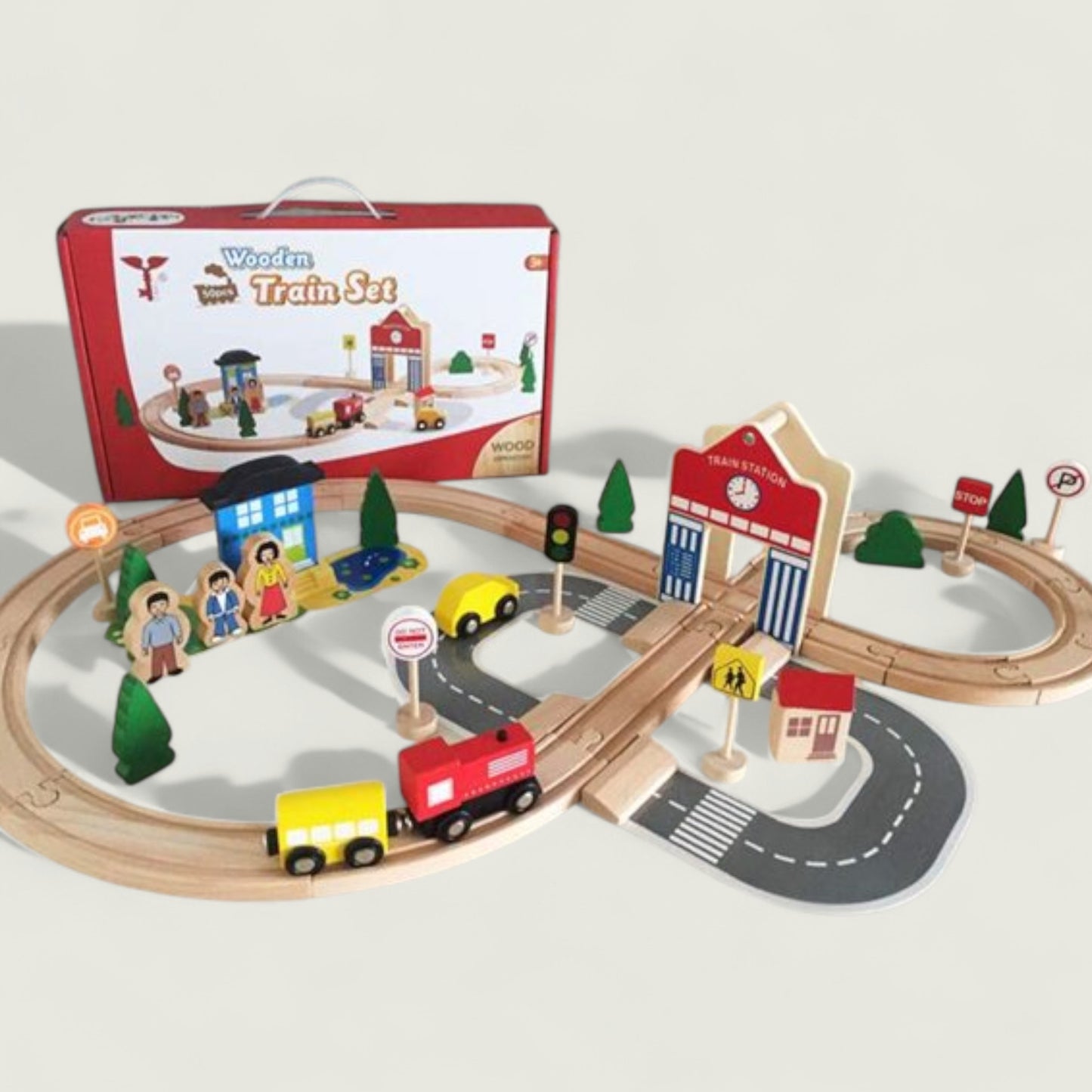 Wooden train set with tracks, cars, and buildings on a white background