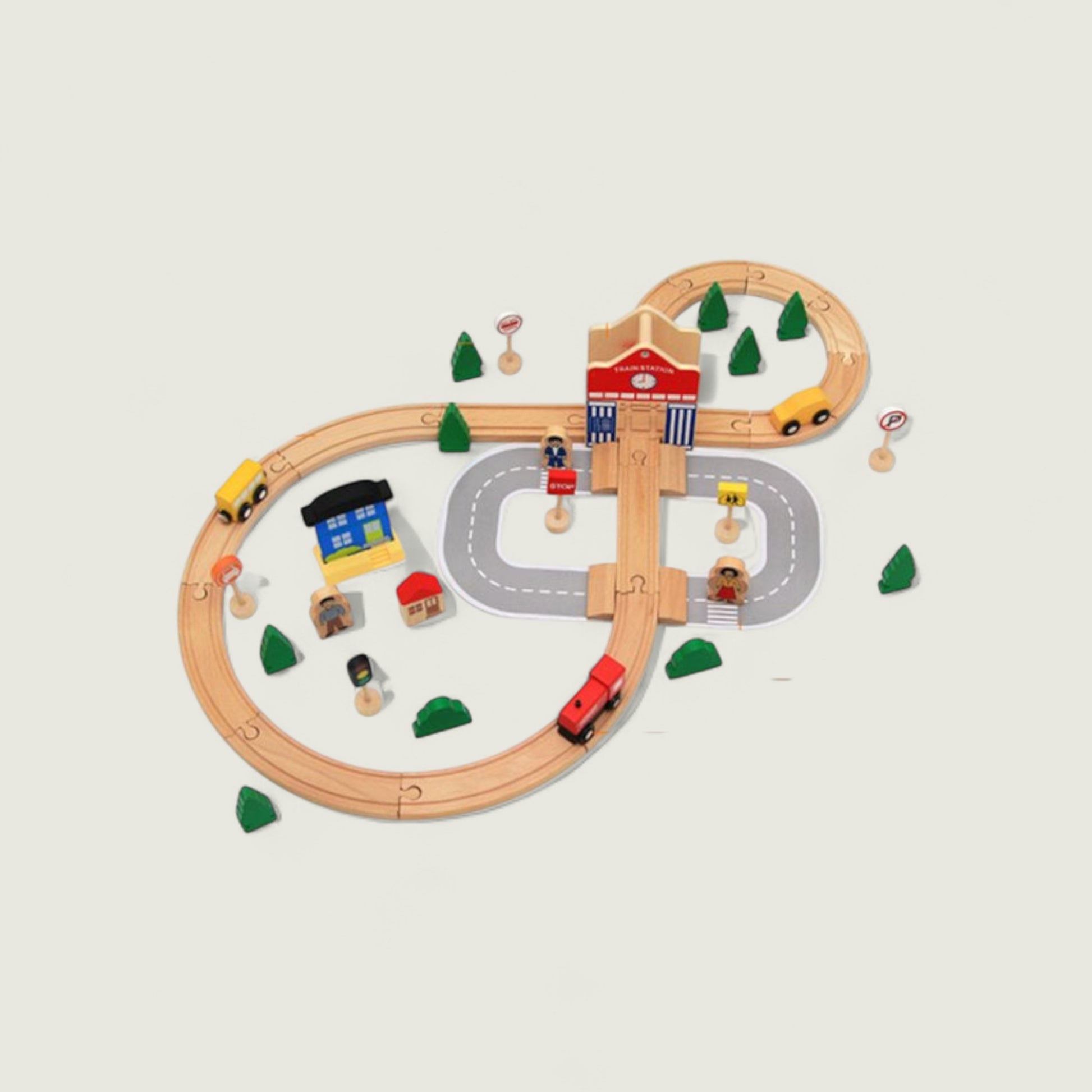 Wooden toy train set with tracks, cars, and buildings on a light background