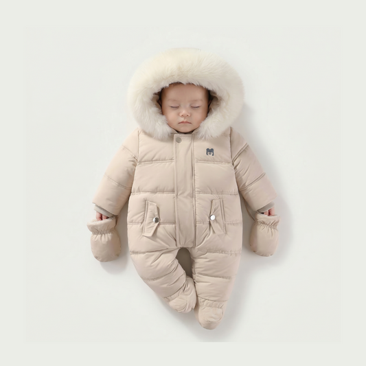 Baby in a beige snowsuit with fur hood on a light gray background