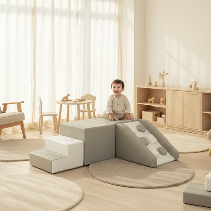 Child playing with soft play structures in a bright, minimalistic room.