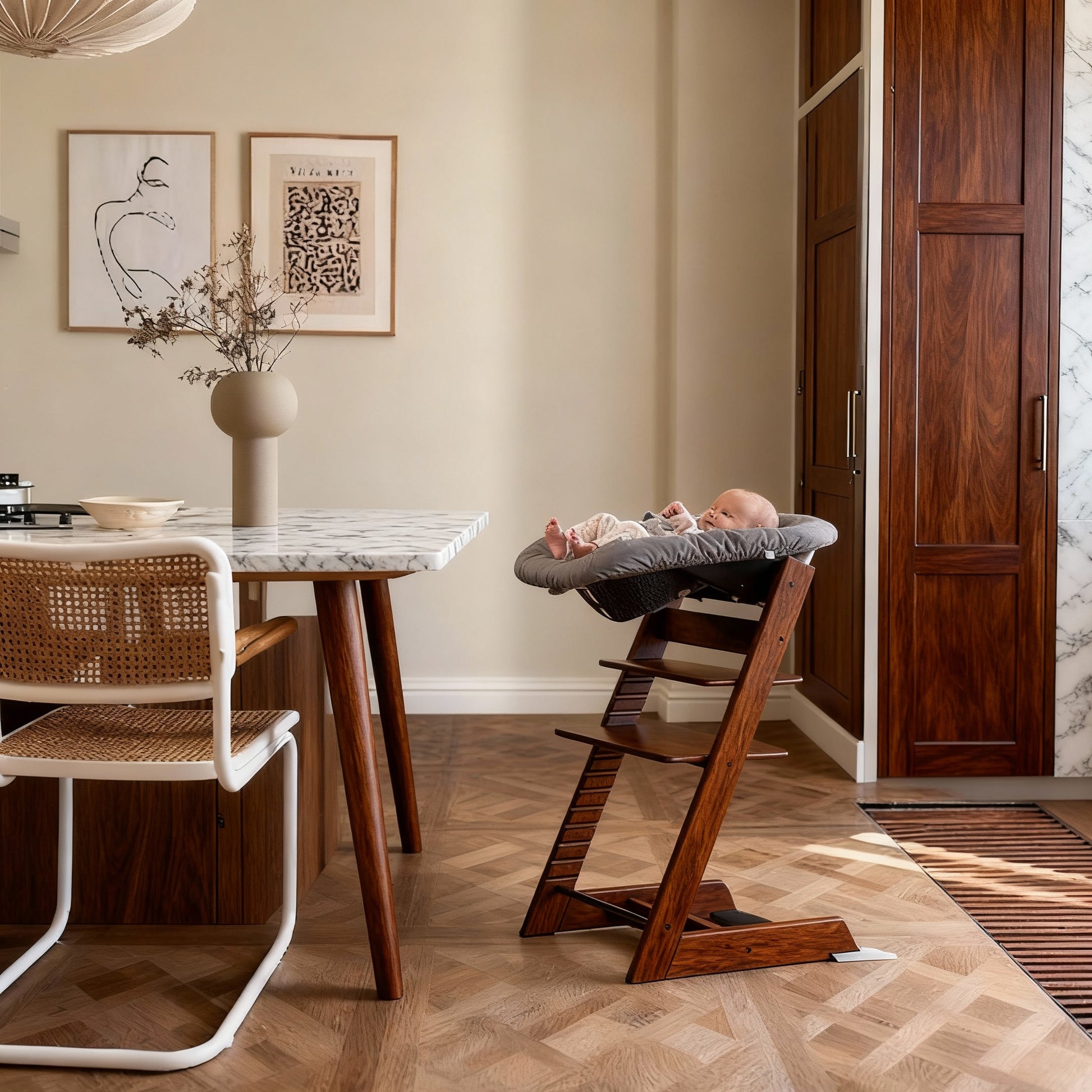 Wooden high chair in a room with a marble table and framed artwork on the wall.