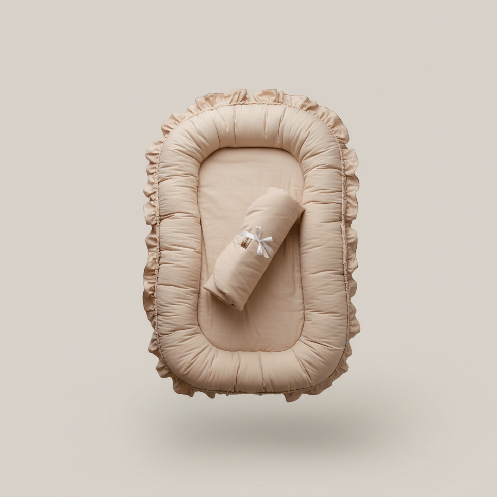 Beige baby nest with rolled blanket on a beige background