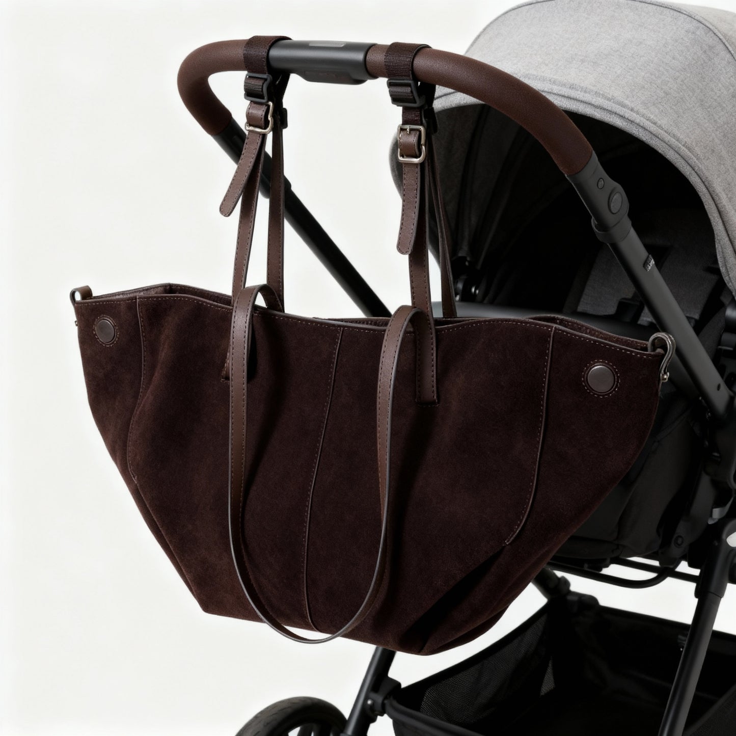 Brown leather baby carrier attached to a stroller on a white background