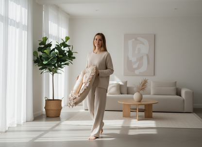 Woman holding a decorative pillow in a modern living room