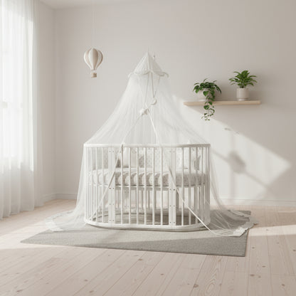 White crib with canopy in a minimalistic room with plants and a hot air balloon decoration.