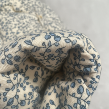 Close-up of fabric with blue floral pattern on beige background